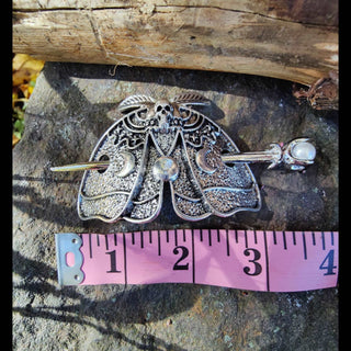 Death moth hair cage with pearl-tipped hairpin shown beside a measuring tape for scale on a stone backdrop