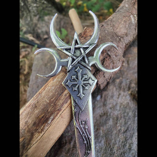 The upper part of the hair dagger, displaying the crescent moons flanking the pentagram, along with a gothic cross set in a diamond-shaped panel. The intricate engravings and aged bronze finish reflect its mystical inspiration.