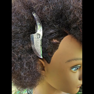 Highlighting the knife hair clip’s adaptability, this photo shows the accessory styled elegantly on textured, natural curls, creating a striking contrast